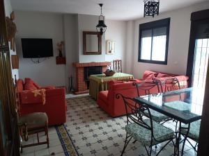 sala de estar con 2 sofás rojos y chimenea en El Corralon de Severo, en Hinojales