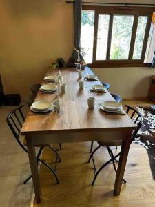 a long wooden table with chairs and plates on it at Gorgeous 2 bedroom, 2 full bath, ski in apartment! in Morzine