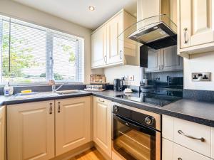 a kitchen with white cabinets and a stove top oven at 2 Orchard Leigh in Austwick