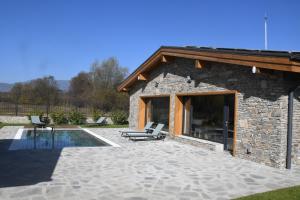 a stone house with a patio and a swimming pool at Къща за гости Авена in Banya