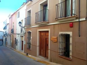 a building with a brown door on a street at Can Perles a beautiful house perfect for relaxing in Tárbena