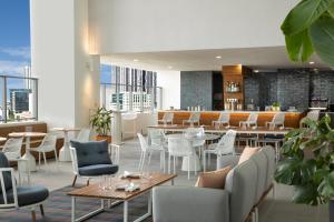 a restaurant with tables and chairs and a bar at Yotel Miami, Select By Hilton in Miami