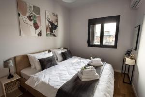 a bedroom with a white bed and a couch at LINA - PG, Riverside Apartment in Podgorica