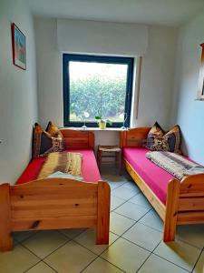 dwa łóżka w pokoju z oknem w obiekcie Ferienwohnung Rosenpflanzer w mieście Bad Oeynhausen