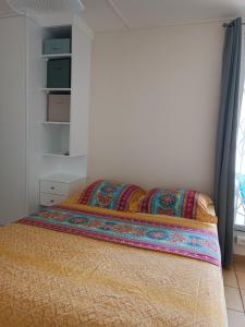 a bedroom with a bed with a blanket on it at Appt Morne la Loge in Pointe-à-Pitre