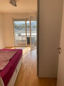 um quarto com uma cama e uma grande janela em Traumapartment neben Universität und Lakeside in Klagenfurt am Wörthersee ! em Klagenfurt