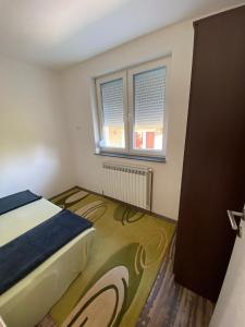 ein kleines Schlafzimmer mit einem Bett und einem Fenster in der Unterkunft Apartment Balicevac Ilidza in Sarajevo