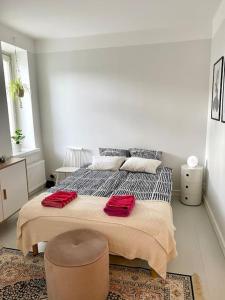 a bedroom with a bed with two red pillows on it at Valoisa ja täysin remontoitu huoneisto in Helsinki