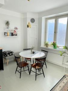 a dining room with a white table and chairs at Valoisa ja täysin remontoitu huoneisto in Helsinki