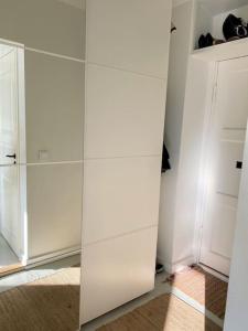 a white closet with a mirror in a room at Valoisa ja täysin remontoitu huoneisto in Helsinki
