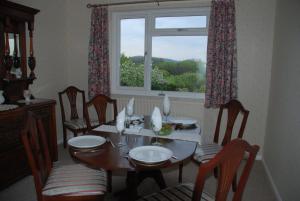 a dining room with a table and chairs and a window at Meadow View, Blue Anchor in Blue Anchor