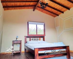 a bedroom with a bed and a window at Hotel Campestre Entre Cerros in Ubalá