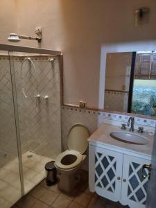 a bathroom with a toilet and a sink and a shower at Chacara Jequitiba in Itu