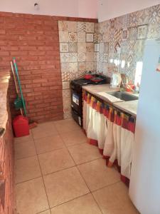 cocina con fregadero y encimera con toallas en El Atardecer en Cortaderas