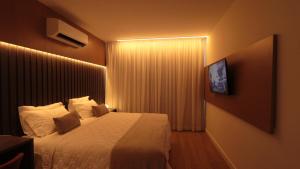 um quarto de hotel com uma cama e uma televisão em Açu Hotel em São João da Barra