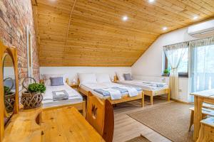 Dos camas en una habitación con techos de madera. en Tündérkert Apartman, en Debrecen 171 fotos más