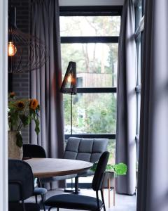 a dining room with a table and chairs and a window at Delightful luxury 2-bedroom holiday home in nature in Otterlo