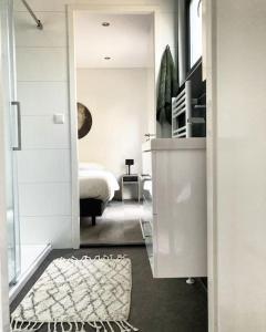 a white bedroom with a bed and a mirror at Delightful luxury 2-bedroom holiday home in nature in Otterlo