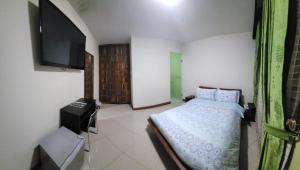 a bedroom with a bed and a flat screen tv at Apartahotel Vincent Suites in Pasto