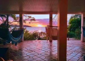 a porch with hammocks and a view of the ocean at Coibahouse in Santa Catalina