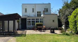 a house with a table and chairs in a yard at Ingledene a Spacious Family House in Bournemouth