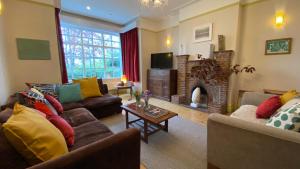 a living room with two couches and a fireplace at Ingledene a Spacious Family House in Bournemouth