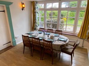 a dining room table with chairs and a large window at Ingledene a Spacious Family House in Bournemouth