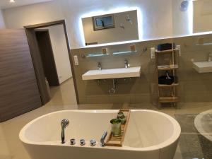 a bathroom with a bath tub and a sink at Appartementhaus Silberborn in Bad Harzburg