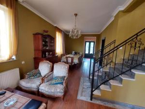 a living room with two chairs and a staircase at Гостевой дом в центре Тбилиси in Tbilisi City