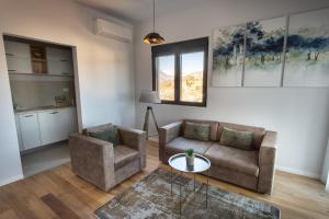 uma sala de estar com um sofá, uma cadeira e uma mesa em LINA - PG, Gorica Park View Apartment em Podgorica