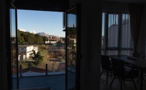um quarto com vista para uma varanda com uma mesa em LINA - PG, Gorica Park View Apartment em Podgorica