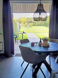 einen Esstisch mit einem blauen Marmortisch und einem Kronleuchter in der Unterkunft Timmershoeve in Vorstenbosch