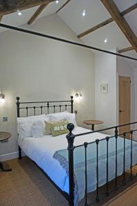 um quarto com uma cama preta e duas mesas em Brook Cottage Askrigg em Askrigg
