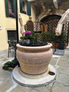 un grande piantatore di pietra con fiori di fronte a un edificio di Corte del Doge di Rialto a Venezia