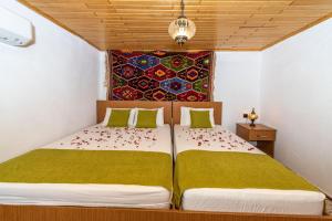 a bedroom with two beds and a tapestry on the wall at Secret Haven Villa in Fethiye