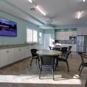 una habitación con mesas y sillas en una cocina en Hacienda del Sol II - 209, en New Smyrna Beach
