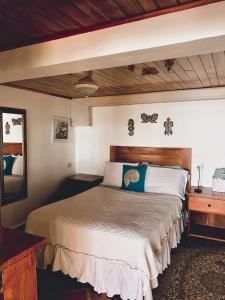 a bedroom with a large bed with a wooden headboard at Coibahouse in Santa Catalina