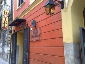 a red building with a sign on the side of it at Hotel Amadeus in Caserta