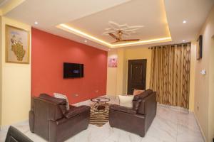 a living room with two chairs and a ceiling fan at Stunning 2-Bedroom Furnished Apartment in Accra in Accra