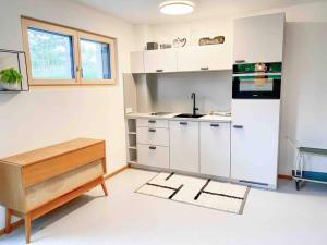 a kitchen with white cabinets and a sink at See-Appartement Wörthsee in Wörthsee