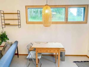 a dining room with a table and a pendant light at See-Appartement Wörthsee in Wörthsee