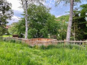 a wooden fence in a field with trees at See-Appartement Wörthsee in Wörthsee