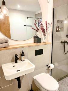 a bathroom with a sink and a toilet and a mirror at See-Appartement Wörthsee in Wörthsee