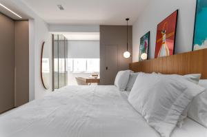 a bedroom with a large white bed and a desk at Agradável em Ipanema - 2 suites completas - J303 Z2 in Rio de Janeiro