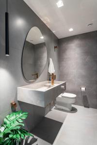 a bathroom with a sink and a toilet and a mirror at Agradável em Ipanema - 2 suites completas - J303 Z2 in Rio de Janeiro