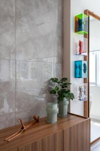 a bathroom with a wooden cabinet with a plant on it at Agradável em Ipanema - 2 suites completas - J303 Z2 in Rio de Janeiro