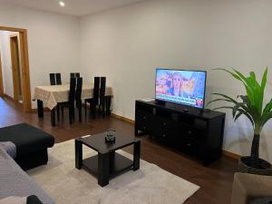 una sala de estar con TV de pantalla plana en una cómoda en Invicta House Gold, en Oporto