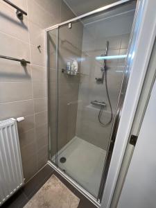 a shower with a glass door in a bathroom at Beautiful 3 bedroom garden-appartment near Knokke-Strand Beach Bar in Knokke-Heist +8 photos