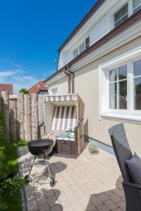 une terrasse avec barbecue et une maison dans l'établissement Kleine Kirr, à Zingst