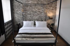 Bett in einem Zimmer mit Ziegelwand in der Unterkunft The Boogie Club in Toruń